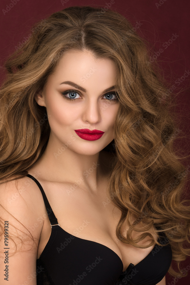 Fototapeta premium Portrait of coquette young curly woman with red lips