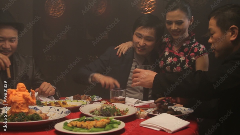 Businessmen drinking and smoking in Chinese restaurant with female on lap Businessmen drinking and smoking in Chinese restaurant with female on lap