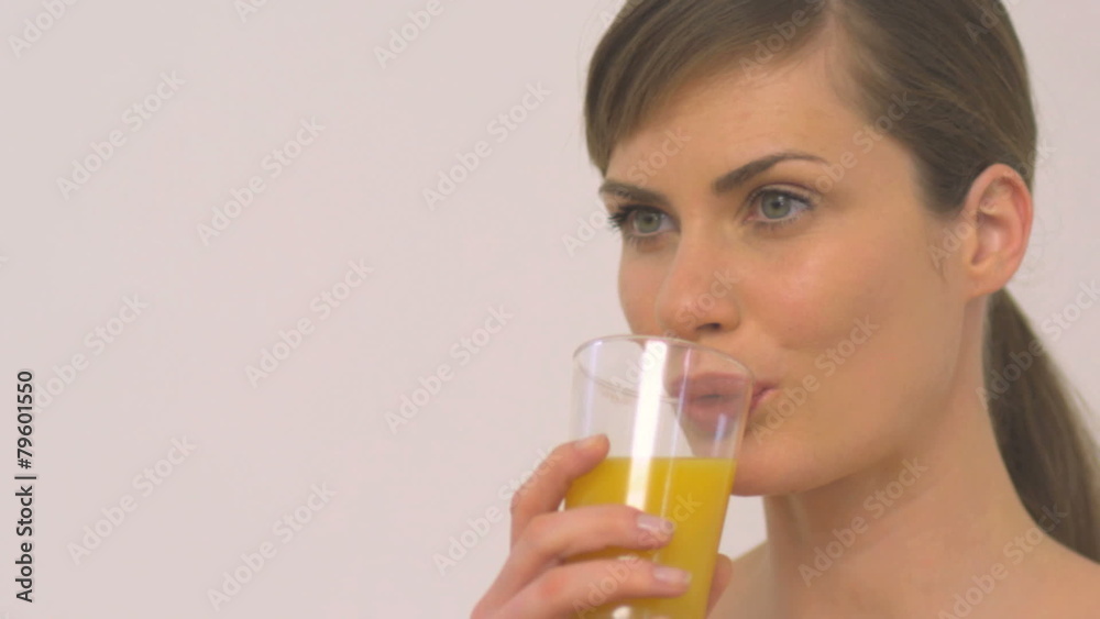 CU PAN OF A WOMAN DRINKING A GLASS OF ORANGE CU PAN OF A WOMAN DRINKING A GLASS OF ORANGE