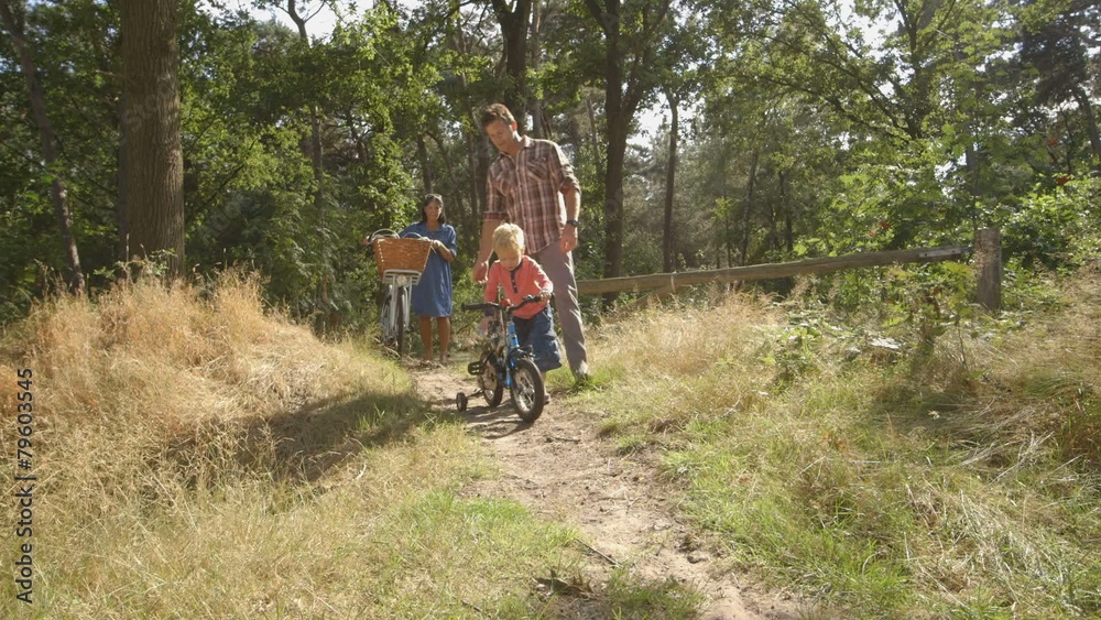 WS Father teaching cycling to his son in forest WS Father teaching cycling to his son in forest
