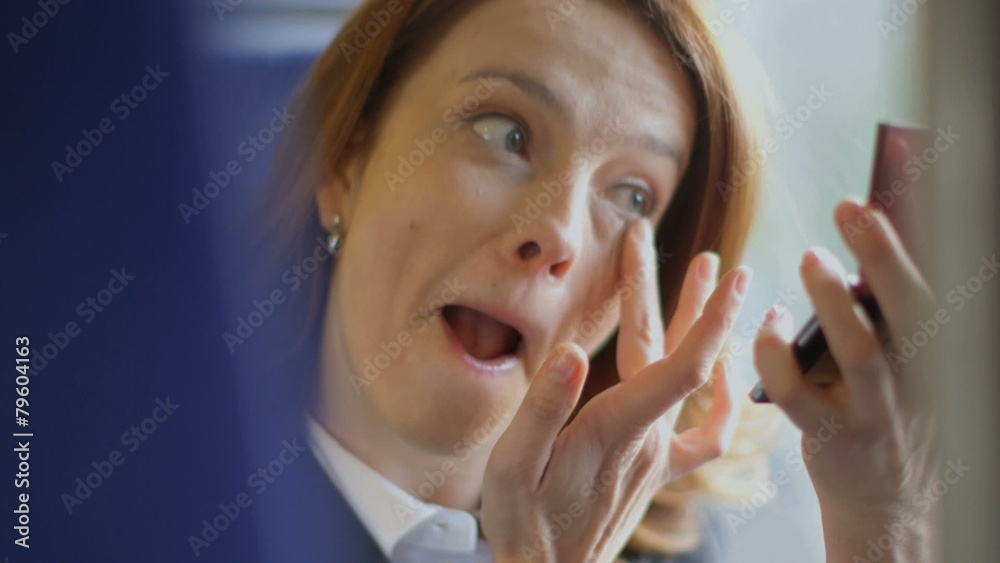 Business man in the background takes a business call whilst Business Woman touched up her make up Business man in the background takes a business call whilst Business Woman touched up her make up