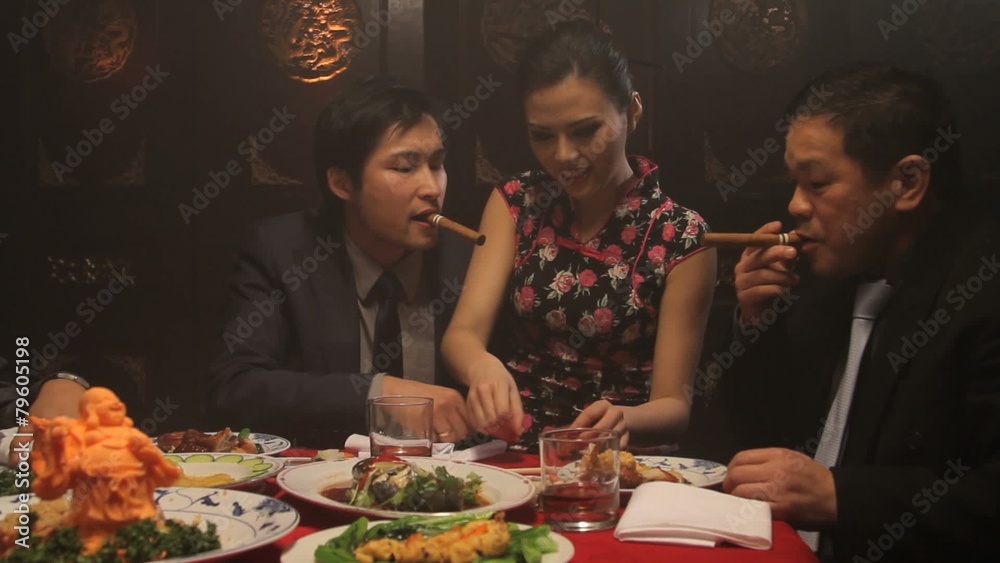Businessmen drinking and smoking in Chinese restaurant with female on lap Businessmen drinking and smoking in Chinese restaurant with female on lap