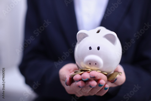Business woman saving money in a piggybank