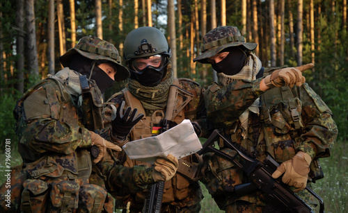 Three german soldiers discuss a plan of action. Coordinate the team.