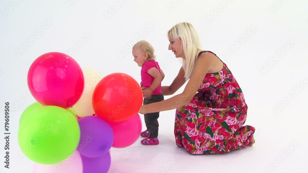 Mother And Her Baby Girl Playing With Multi-Colored Balloons Mother And Her Baby Girl Playing With Multi-Colored Balloons