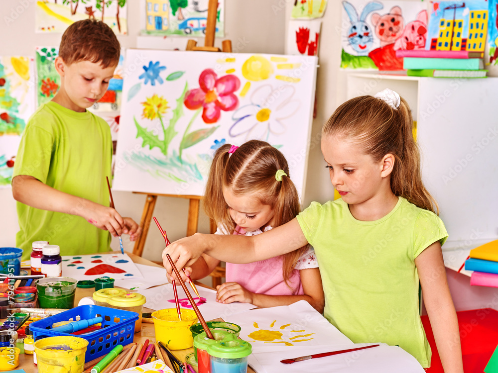 Fototapeta premium Child painting at easel.