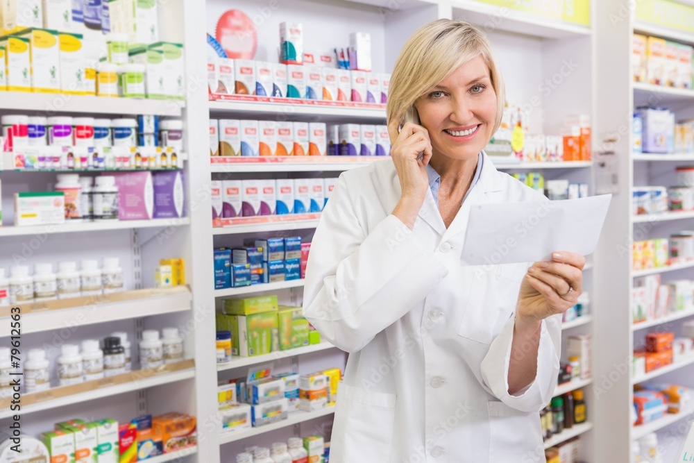 Smiling pharmacist on the phone reading prescription