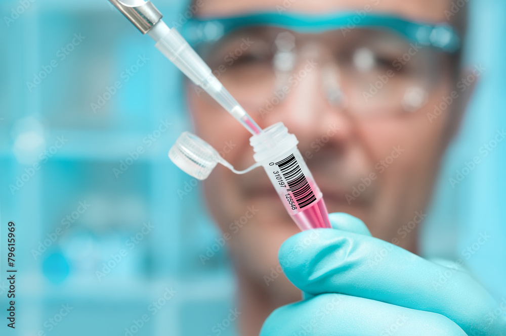 Scientist or tech holds liquid biological sample Scientist or tech holds liquid biological sample