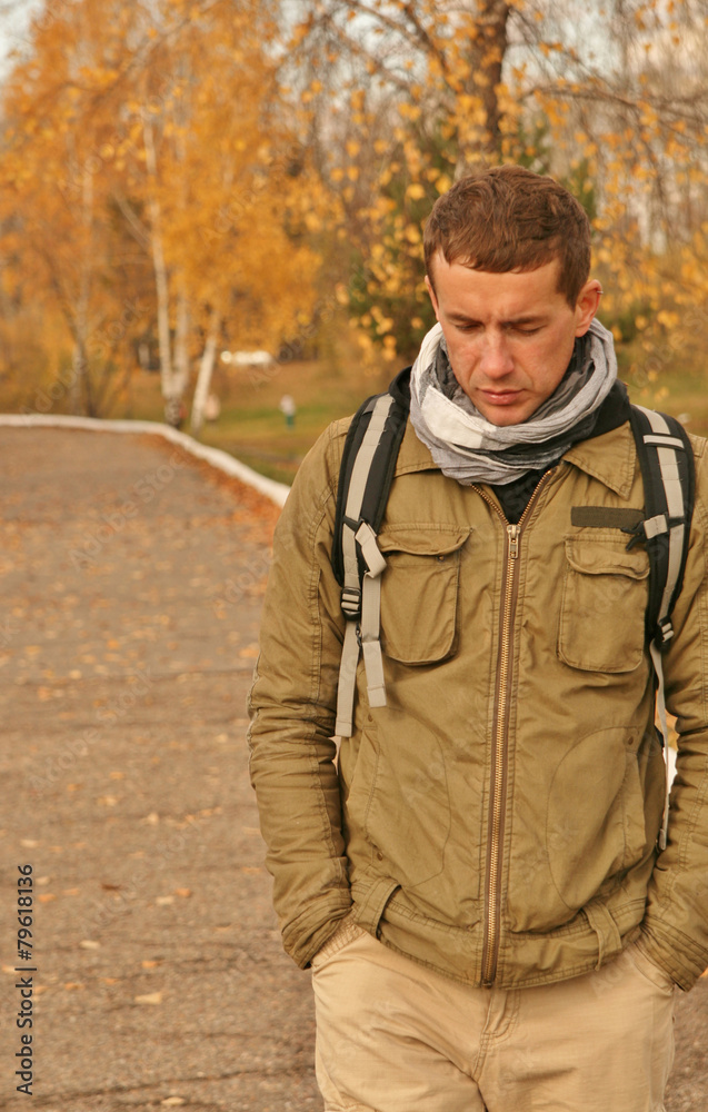 a man walks in autumn park