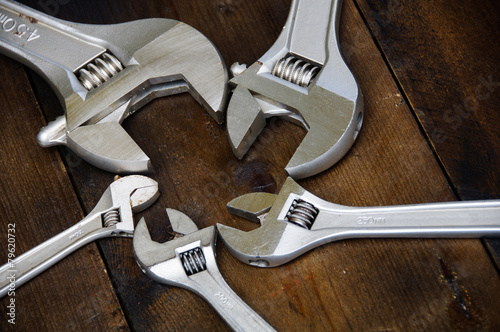 Spanner or adjustable wrench on wooden back ground