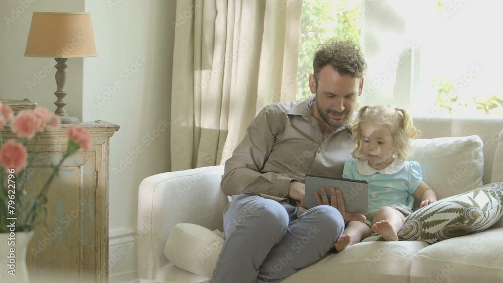 Father showing digital tablet to his daughter Father showing digital tablet to his daughter