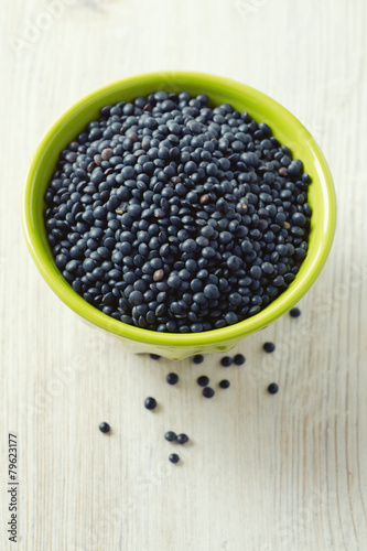 black lentils on table in bowl