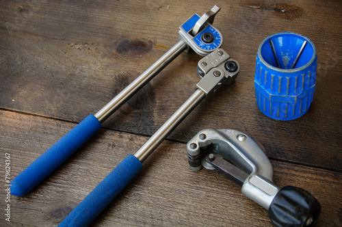Tube bender or pipe bender tools on wooden background.