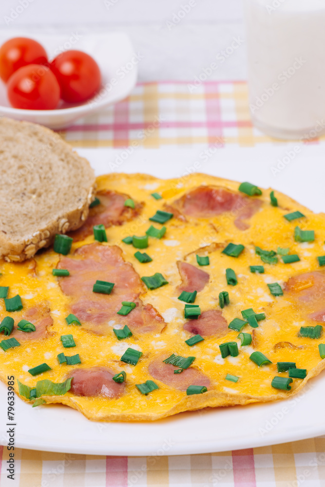 Omelet with ham and cherry tomato on a table