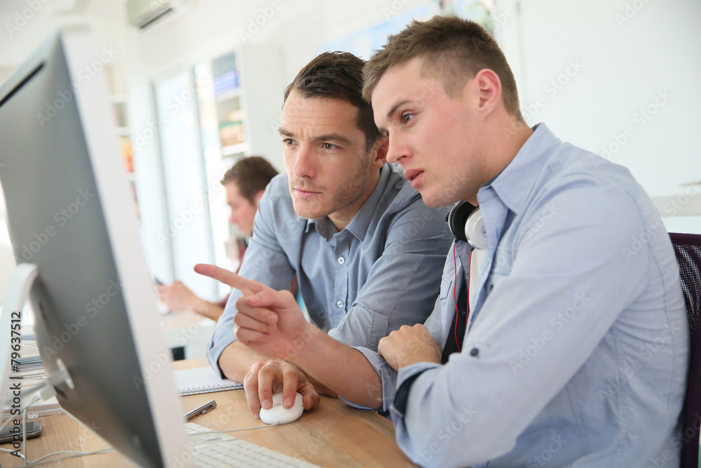 © goodluz - Teacher with student working on desktop