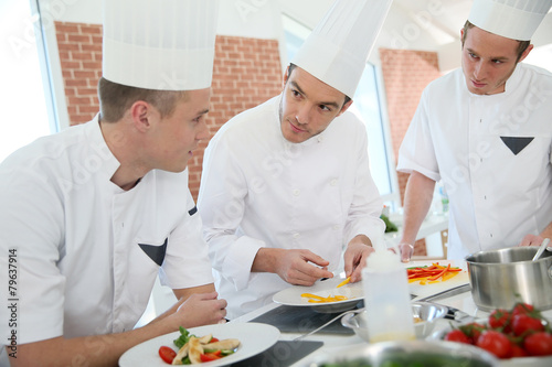 Chef training students in restaurant kitchen