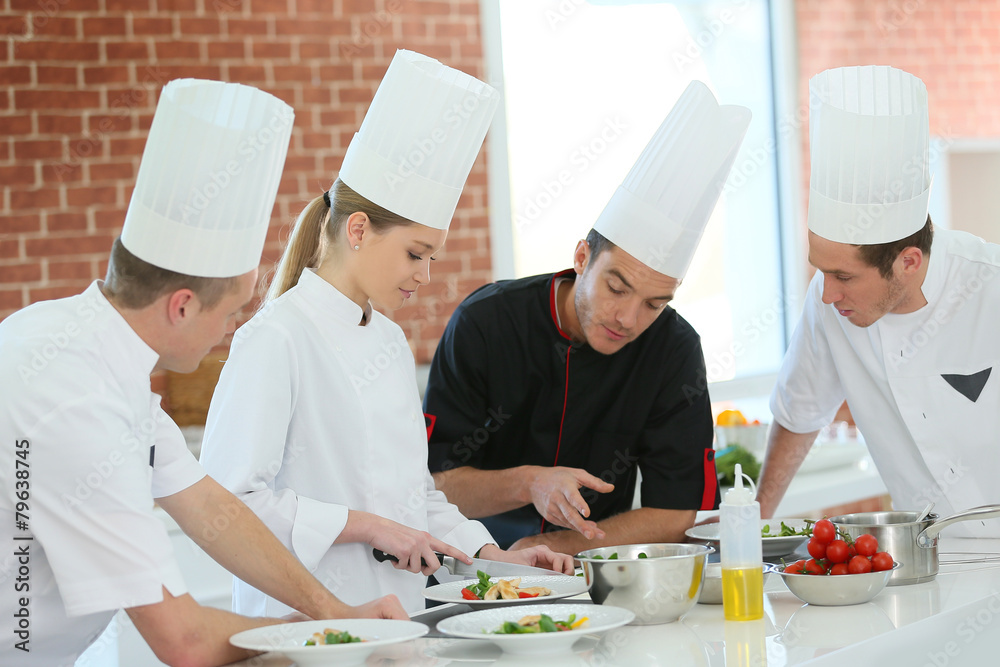 Chef training students in restaurant kitchen