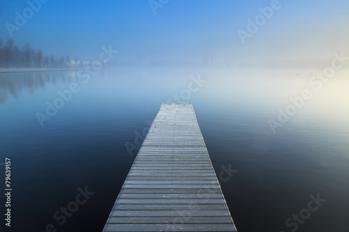 Fotografie, Obraz Empty jetty in a foggy lake during sunrise.
