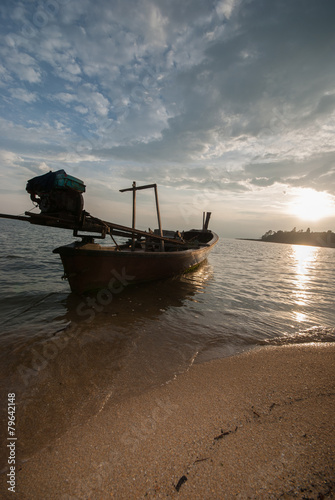 Boat on the beach at sunrise in tide time.
