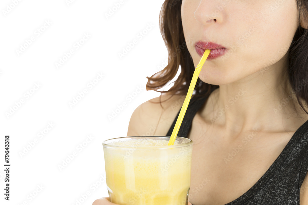 Woman drinking a big glass of banana smoothie Woman drinking a big glass of banana smoothie