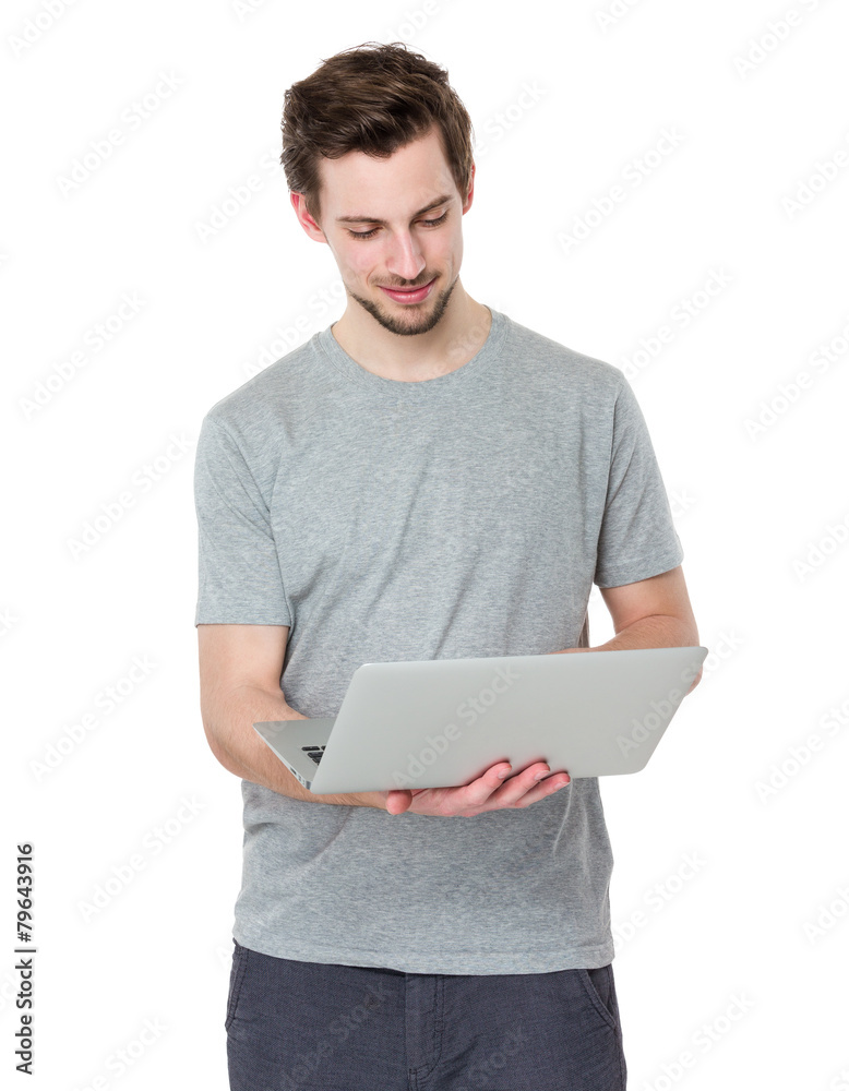Smiling young man working on laptop Smiling young man working on laptop