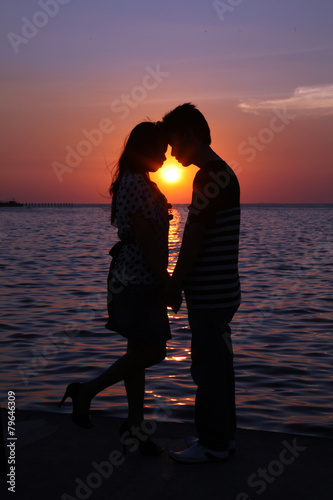 couple at sunset silhouette beach dawn 