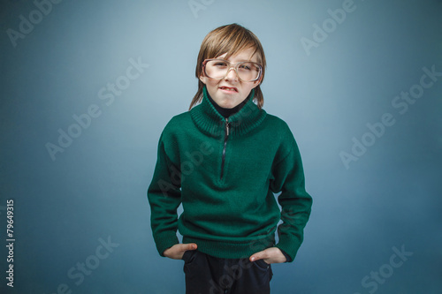 European-looking boy of ten years in glasses hands pockets on