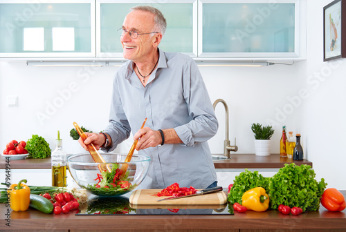 Mature man in the kitchen prepare salad VII