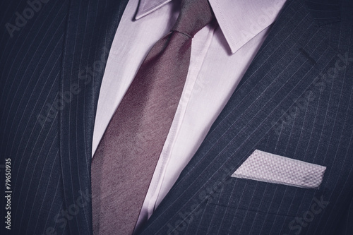 Closeup of suit jacket, handkerchief in pocket, shirt, necktie