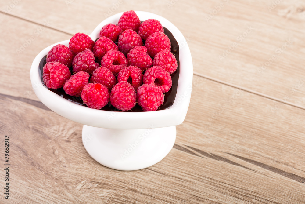 Heart-shaped plate of raspberries in chocolate sauce Heart-shaped plate of raspberries in chocolate sauce