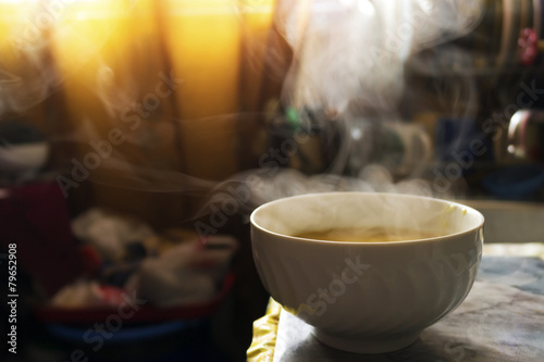 Steaming hot soup in a bowl in the kitchen under warm sunlight