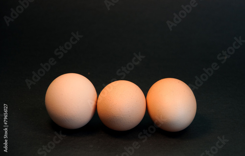 Three eggs on black background