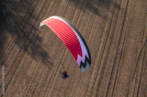 aerial view of paramotor flying over the harvest field photo