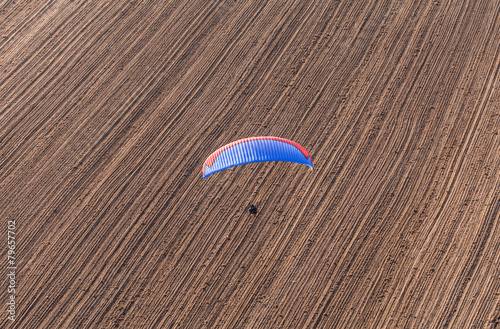 aerial view of paramotor flying over the harvest field