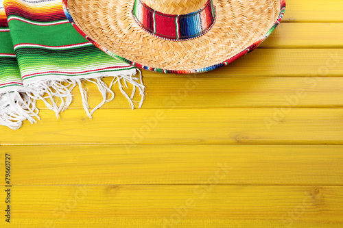 Mexican background with sombrero straw hat and traditional serape rug or blanket on old planked pine wood Mexico holiday vacation cinco de mayo photo 