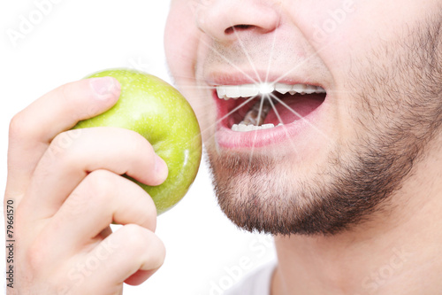 Man biting fresh green appl...