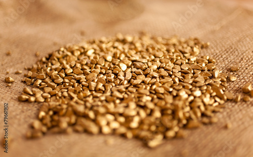 mound of golden nuggets lying on burlap