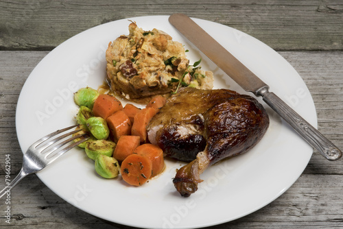 Roasted duck with apple and herb stuffing, carrots and Brussels