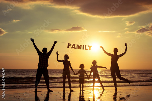 Happy family standing on the beach