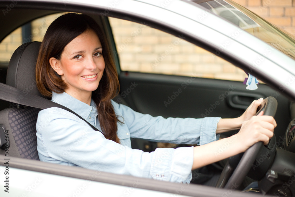 young woman driving her car with her seatbelt fastened