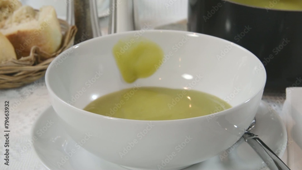 Spooning pea soup into a bowl Spooning pea soup into a bowl