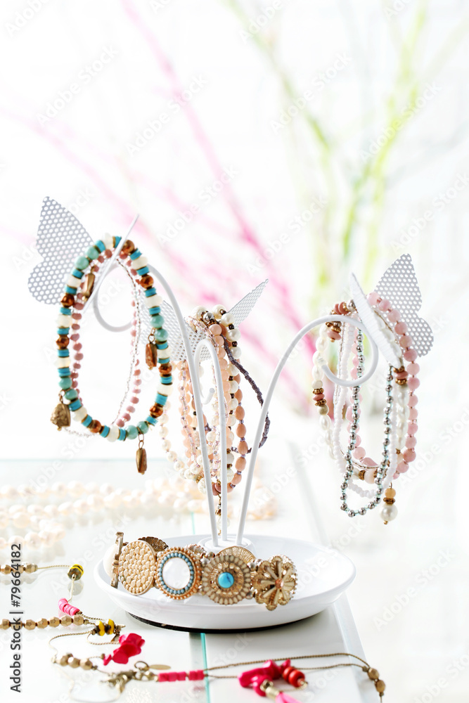 Fototapeta premium Decorative stand with jewelry and bijouterie on table in room