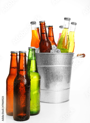 Glassware of different drinks in metal bucket with ice cubes