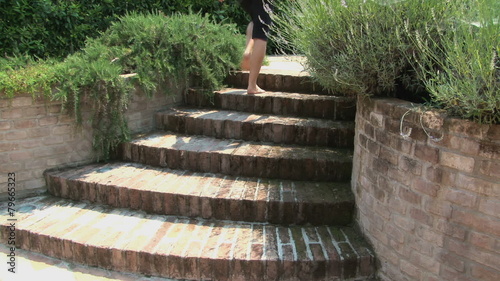 Barefoot woman in a garden going up a staircase among lavender