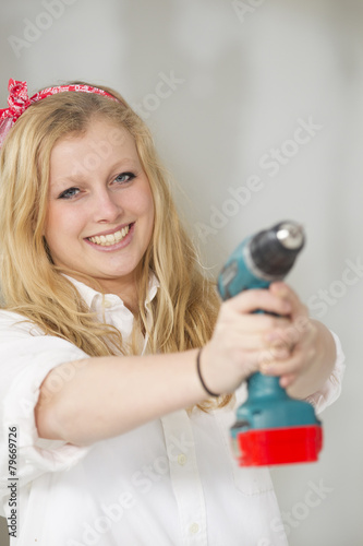 Happy young woman doing a odd-job in her new house