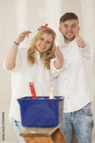 .Happy young couple doing a odd-job in their new house.