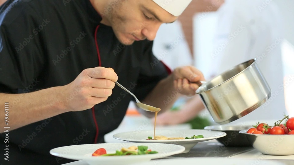 Chef in restaurant kitchen preparing dish Chef in restaurant kitchen preparing dish