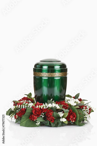 Grüne Urne aus Metall mit Blumenkranz photo