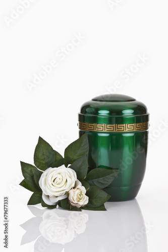 Bestattungsurne, grüne Urne aus Metall mit Blumen photo