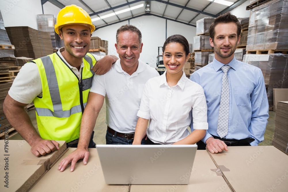 Warehouse managers and worker smiling at camera Warehouse managers and worker smiling at camera